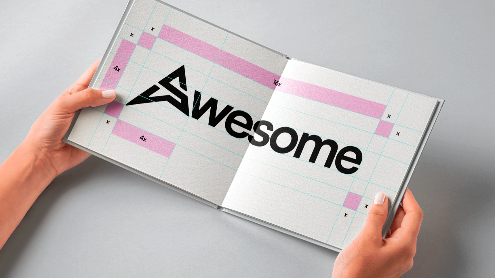 An open book showing the black Awesome wordmark on a construction grid with clear-space markers