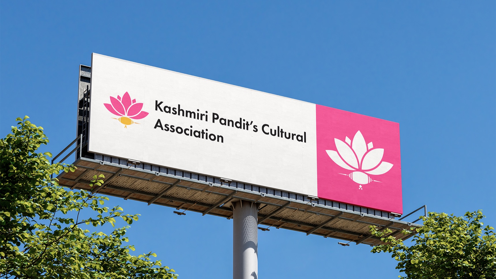 KPCA billboard against a blue sky: horizontal logo on white and the white lotus on a deep pink panel