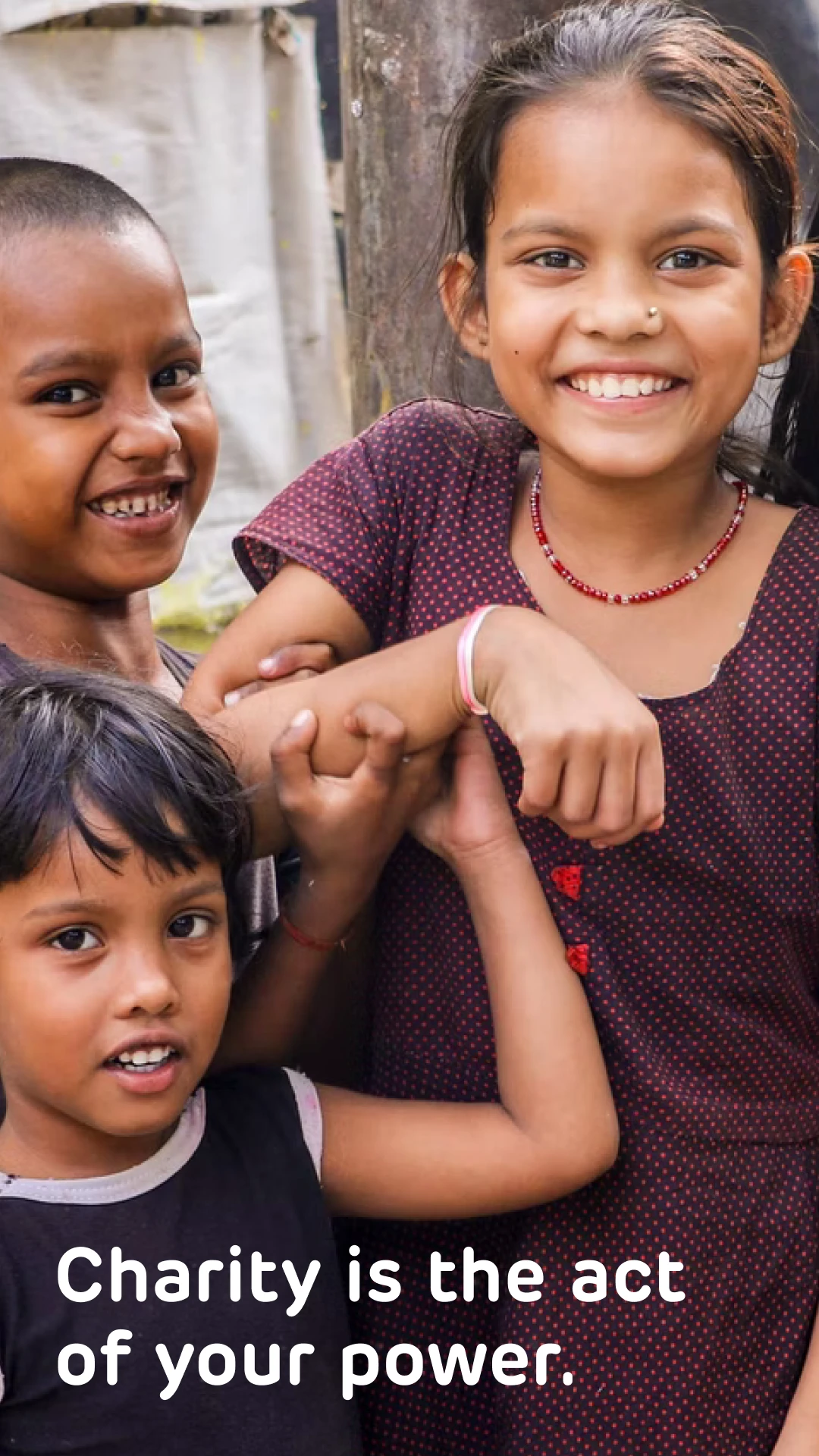 OurKarma story screen: three smiling children with the line Charity is the act of your power